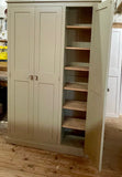 A off white three door hall storage cupboard with contrast wood finish, featuring double doors section with shelves inside, handmade in the UK.
