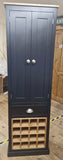 Tall dark gray cabinet with a wooden shelf on a wooden floor.