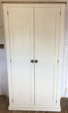 An off white hallway storage cupboard with coat hooks and three shelves, displayed closed, with Contrast wood knobs and contrast wood top 