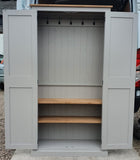 A white hall cloak room cupboard with hooks and shelves, available in various widths, with full height doors and wooden knobs.