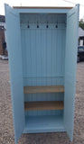 A blue hall cloak room cupboard with hooks and shelves, available in various widths, with full height doors and wooden knobs.