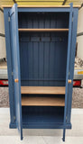 A blue hallway storage cupboard with coat hooks and three shelves, displayed open and closed, 