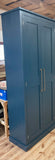 A blue hallway storage cupboard with coat hooks and three shelves, displayed closed, with customers own handles